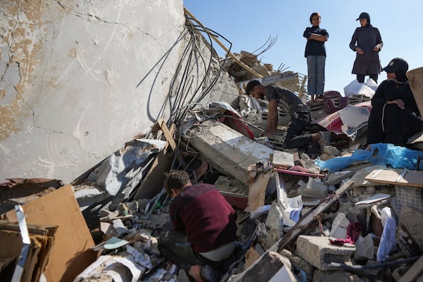 Members of the Abu Al Zamar family salvage items from under the rubble of his destroyed family home, in Rafah, southern Gaza Strip, Tuesday, Jan. 21, 2025, days after the ceasefire deal between Israel and Hamas came into effect. (AP Photo/Abdel Kareem Hana)