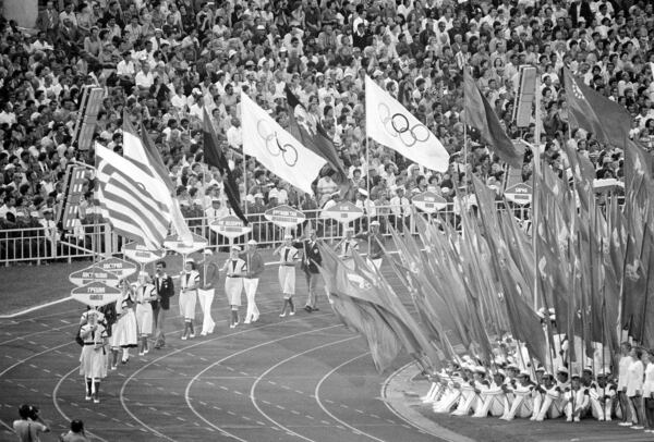 FILE - Flag and sign bearers march around Moscow's Lenin Stadium during closing ceremonies of the XXII Summer Olympic Games in Moscow, on Aug. 3, 1980. (AP Photo/File)