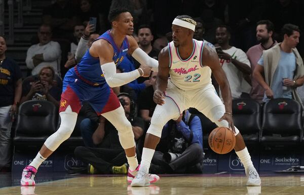 Denver Nuggets guard Russell Westbrook, left, defends Miami Heat forward Jimmy Butler (22) during the first half of an NBA basketball game, Friday, Jan. 17, 2025, in Miami. (AP Photo/Lynne Sladky)