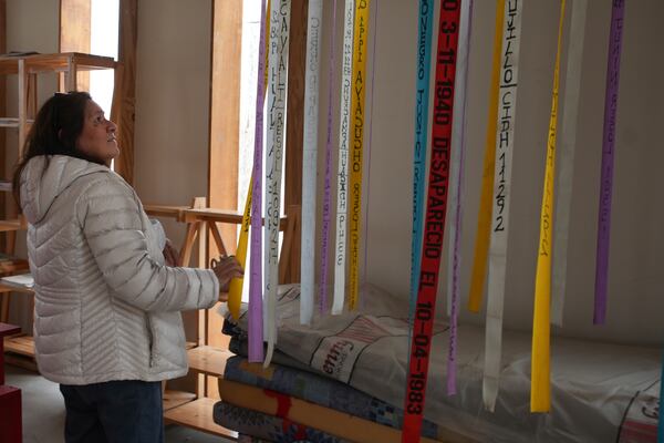 Luyeva Yangali looks at ribbons with the names of people who were disappeared during Peru's internal armed conflict (1980-2000) at the House of Memory museum in Lima, Peru, Sunday, Oct. 20, 2024. (AP Photo/Guadalupe Pardo)