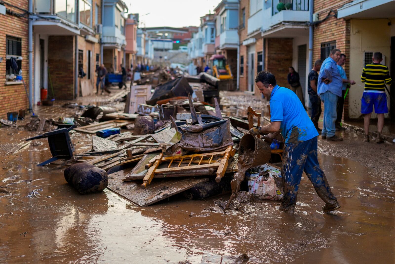 A man cleans his house affected by floods in Utiel, Spain, Wednesday, Oct. 30, 2024. (AP Photo/Manu Fernandez)