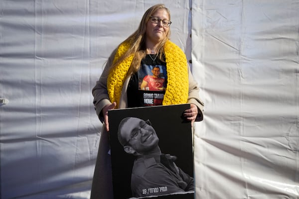 Herut Nimrodi poses for a portrait with a poster of her son, Tamir Nimrodi, an Israeli soldier taken hostage on Oct. 7, 2023, and being held by Hamas militants in the Gaza Strip, at a rally for hostages and their families in Tel Aviv, Israel, on Tuesday, Jan. 14, 2025. (AP Photo/Maya Alleruzzo)