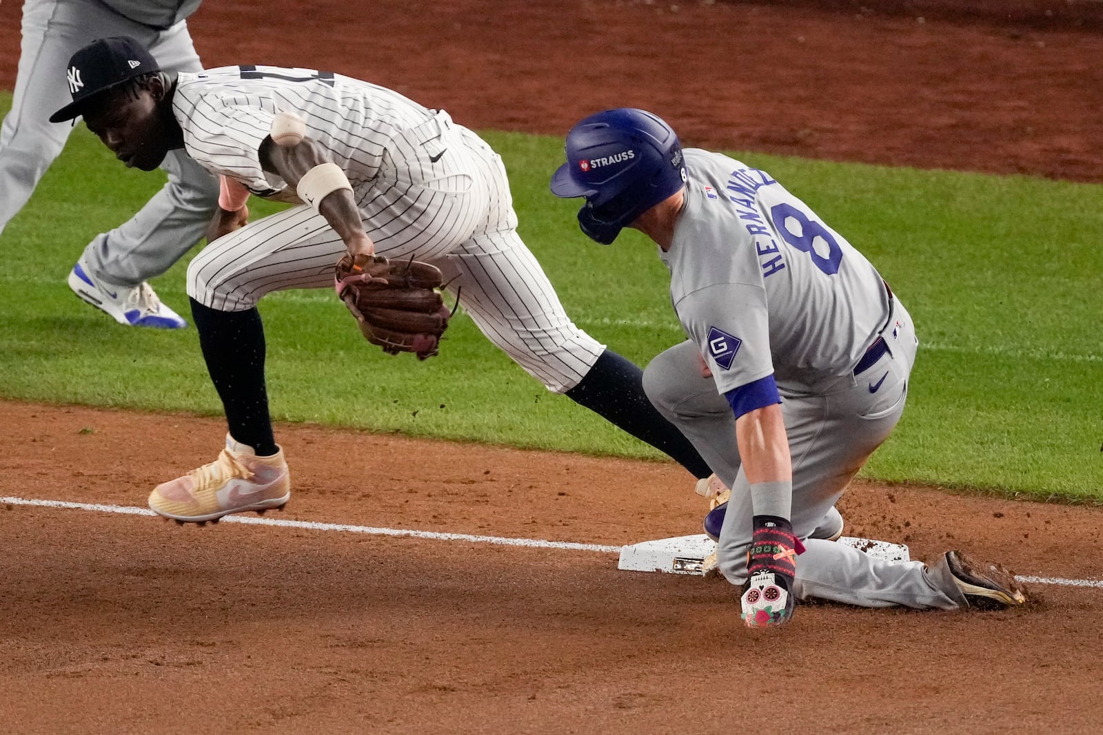 Los Angeles Dodgers' Kiké Hernández, right, is safe at third as New York Yankees third baseman Jazz Chisholm Jr. reaches for a throw from shortstop Anthony Volpe during the fifth inning in Game 5 of the baseball World Series, Wednesday, Oct. 30, 2024, in New York. Volpe was charged with a throwing error. (AP Photo/Frank Franklin II)