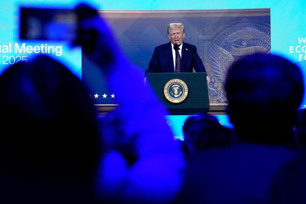 People follow a virtual speech of U.S. president Donald Trump at the Annual Meeting of World Economic Forum in Davos, Switzerland, Thursday, Jan. 23, 2025. (AP Photo/Markus Schreiber)