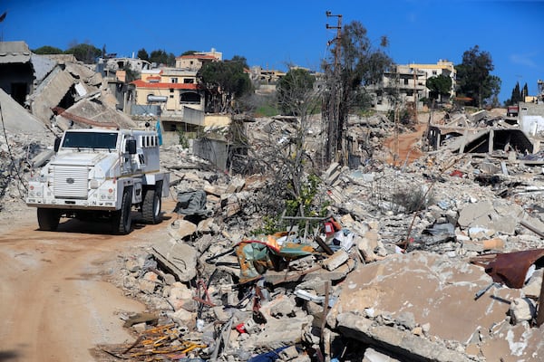 An U.N peacekeeper armoured vehicle drives past the destruction caused by the Israeli air and ground offensive in Mays al-Jabal, southern Lebanon, Saturday, Jan. 25, 2025. (AP Photo/Mohammed Zaatari)