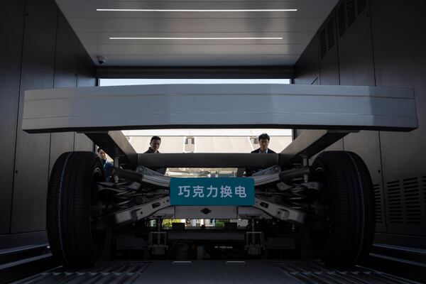 Attendees look at the next generation battery swapping station by China-based CATL battery manufacturing company, before a launch presentation in Xiamen in Xiamen, Fujian province, China, Wednesday, Dec. 18, 2024. (AP Photo/Ng Han Guan)