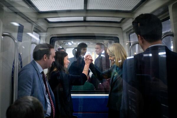 Sen. Lisa Murkowski, R-Alaska, right, shakes hands with Sen. Katie Britt, R-Ala., left, as they ride the Senate subway at the Capitol, Thursday, Jan. 23, 2025, in Washington. (AP Photo/Rod Lamkey, Jr.)