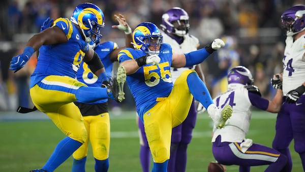 Los Angeles Rams defensive tackle Kobie Turner (91) and Los Angeles Rams defensive tackle Braden Fiske (55) celebrate a sack on Minnesota Vikings quarterback Sam Darnold (14) during the second half of an NFL wild card playoff football game, Monday, Jan. 13, 2025, in Glendale, Ariz. (AP Photo/Ross D. Franklin)