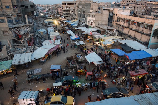 Palestinians walk along a street market in Khan Younis, central Gaza Strip, Saturday Jan. 18, 2025.(AP Photo/(AP Photo/Jehad Alshrafi)