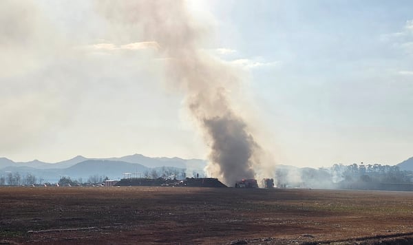 Firefighters work to extinguish a fire off the runway of Muan International Airport in Muan, South Korea, Sunday, Dec. 29, 2024. (Maeng Dae-hwan/Newsis via AP)