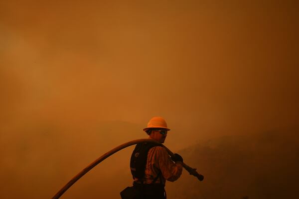 FILE - A firefighter monitors the advance of the Palisades Fire in Mandeville Canyon on Jan. 11, 2025, in Los Angeles. (AP Photo/Eric Thayer, File)