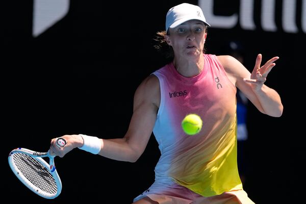 Iga Swiatek of Poland plays a forehand return to Emma Navarro of the U.S. during their quarterfinal match at the Australian Open tennis championship in Melbourne, Australia, Wednesday, Jan. 22, 2025. (AP Photo/Manish Swarup)