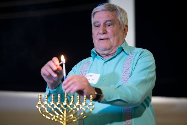 Rabbi Peter Tarlow lights a candle on a menorah during a Chicanukah event at Holocaust Museum Houston on Thursday, Dec. 19, 2024, in Houston. (AP Photo/Annie Mulligan)