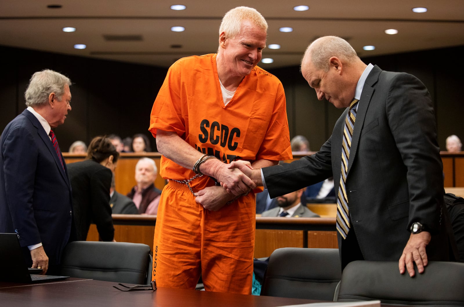 FILE- Alex Murdaugh, convicted of killing his wife, Maggie, and younger son, Paul, in June 2021, greets his defense attorney Jim Griffin before a hearing on the motion for a retrial, Tuesday, Jan. 16, 2024, at the Richland County Judicial Center, in Columbia, S.C. (Gavin McIntyre/The Post and Courier via AP, Pool, File)