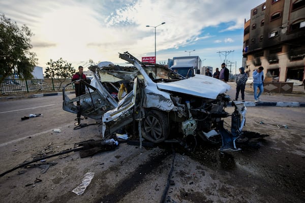 Palestinians inspect a car targeted in an overnight Israeli airstrike that killed its occupants in the town of Khan Younis, southern Gaza Strip, Saturday, Jan. 4, 2025. (AP Photo/Abdel Kareem Hana)