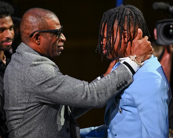 Colorado’s Travis Hunter, right, and coach Deion Sanders embrace after Hunter won the Heisman Trophy as the outstanding player in college football, Saturday, Dec. 14, 2024, in New York. (Todd Van Emet/Heisman Trust via AP, Pool)