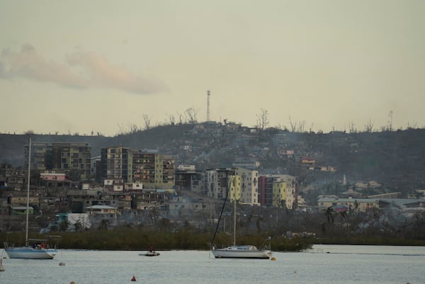 Smoke rises from destroyed dwellings Wednesday, Dec. 18, 2024 in the French Indian Ocean island of Mayotte. (AP Photo/Adrienne Surprenant)