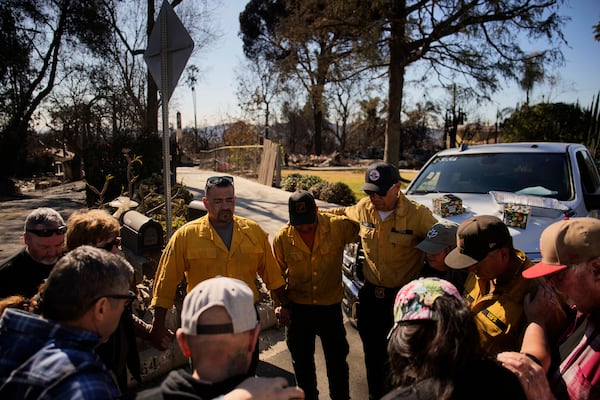 Firefighters with the U.S. Forest Service gather to pray with others, Wednesday, Jan. 15, 2025, in Altadena, Calif. (AP Photo/John Locher)