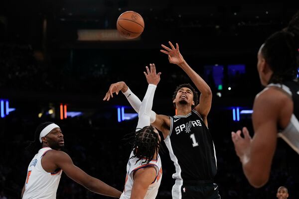 San Antonio Spurs' Victor Wembanyama, second from right, tries to grab a rebound over New York Knicks defenders during the first half of an NBA basketball game, Wednesday, Dec. 25, 2024, in New York. (AP Photo/Seth Wenig)