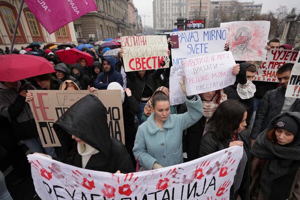 People stopping traffic, stand in silence during ongoing protests that erupted after a concrete canopy fell last month and killed 15 people, in Belgrade, Serbia, Friday, Dec. 20, 2024. (AP Photo/Darko Vojinovic)