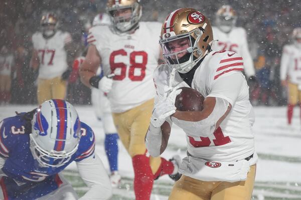 San Francisco 49ers running back Isaac Guerendo, right, runs for a touchdown past Buffalo Bills safety Damar Hamlin (3) during the second half of an NFL football game in Orchard Park, N.Y., Sunday, Dec. 1, 2024. (AP Photo/Gene J. Puskar)