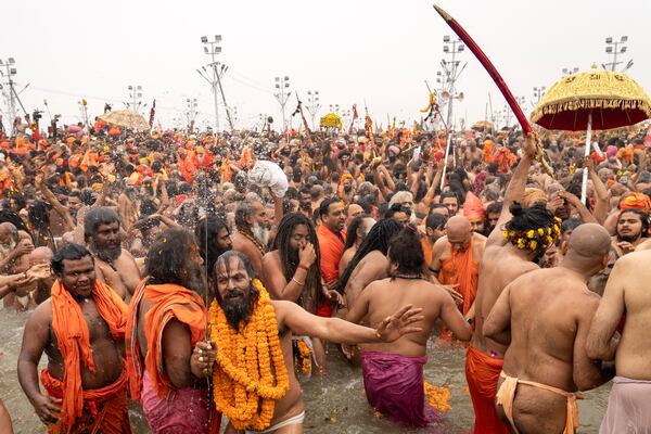 Hindu ascetics and holy men bathe at the confluence of the Ganges, the Yamuna and the mythical Saraswati rivers on the second day of the 45-day-long Maha Kumbh festival in Prayagraj, India, Tuesday, Jan. 14, 2025. (AP Photo/Ashwini Bhatia)