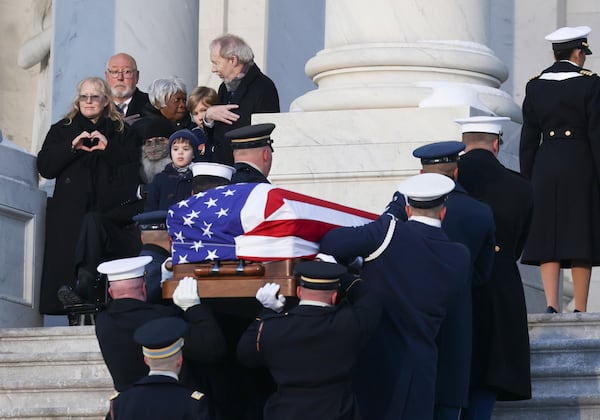 A joint services military body bearer team carries the flag-draped casket of former President Jimmy Carter up the steps into the U.S Capitol, Tuesday, Jan. 7, 2025, in Washington. Carter died Dec. 29 at the age of 100. (Evelyn Hockstein/Pool via AP)