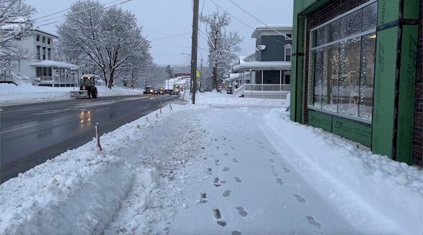 Light snow covers the sidewalk in Lowville, N.Y., on Saturday, Nov. 30, 2024. (AP Photo/Cara Anna)