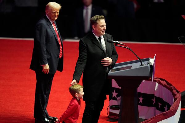 Elon Musk, with his son X Æ A-Xii, speaks as President-elect Donald Trump listens at a rally ahead of the 60th Presidential Inauguration, Sunday, Jan. 19, 2025, in Washington. (AP Photo/Alex Brandon)