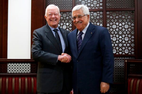 FILE - Palestinian President Mahmoud Abbas, right, shakes hands with former President Jimmy Carter during their meeting in the West Bank city of Ramallah, May 2, 2015. (Abbas Momani/Pool Photo via AP, File)