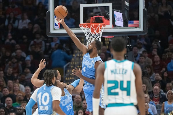 Cleveland Cavaliers' Evan Mobley (4) goes for the ball in front of teammate Isaac Okoro (35), Darius Garland (10) and Charlotte Hornets' Brandon Miller (24) during the first half of an NBA basketball game in Cleveland, Sunday, Nov 17, 2024. (AP Photo/Phil Long)