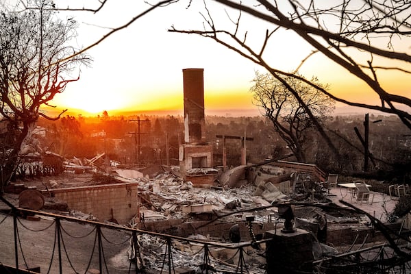 The sun rises behind a home destroyed by the Palisades Fire in the Pacific Palisades community of Los Angeles on Sunday, Jan. 12, 2025, (AP Photo/Noah Berger)