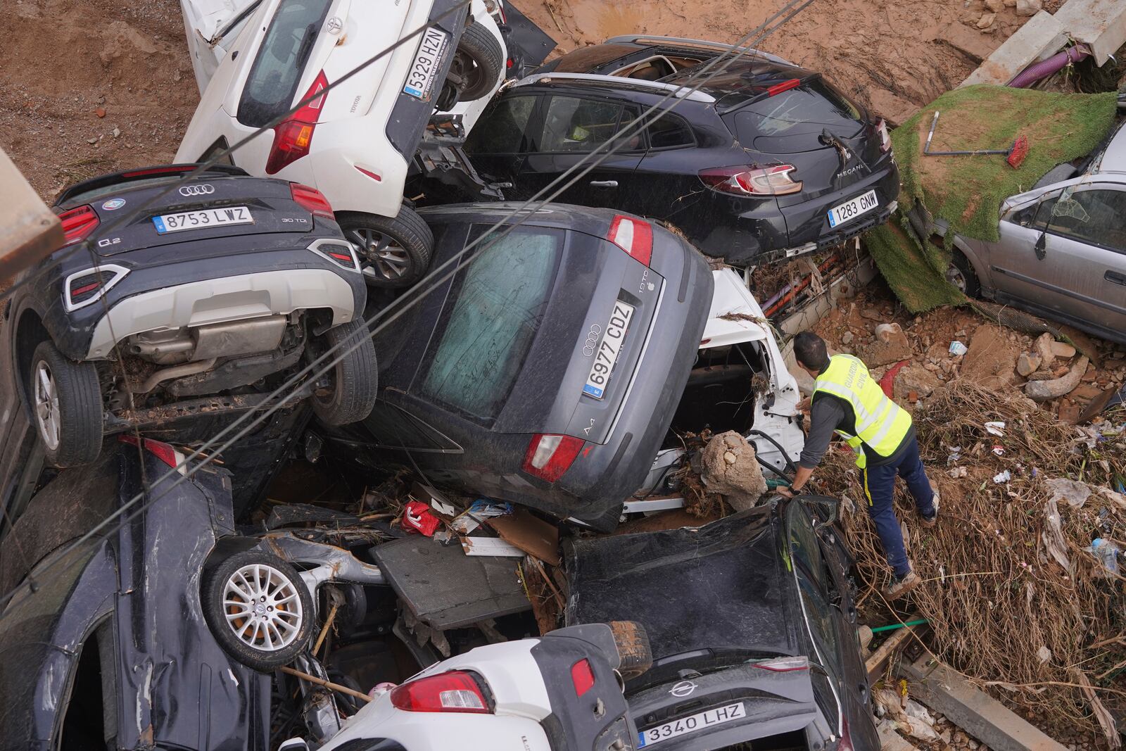 A civil guard seaches for survivors in cars piled up on the outskirts of Valencia, Spain, Friday, Nov. 1, 2024 after flooding. (AP Photo/Alberto Saiz)