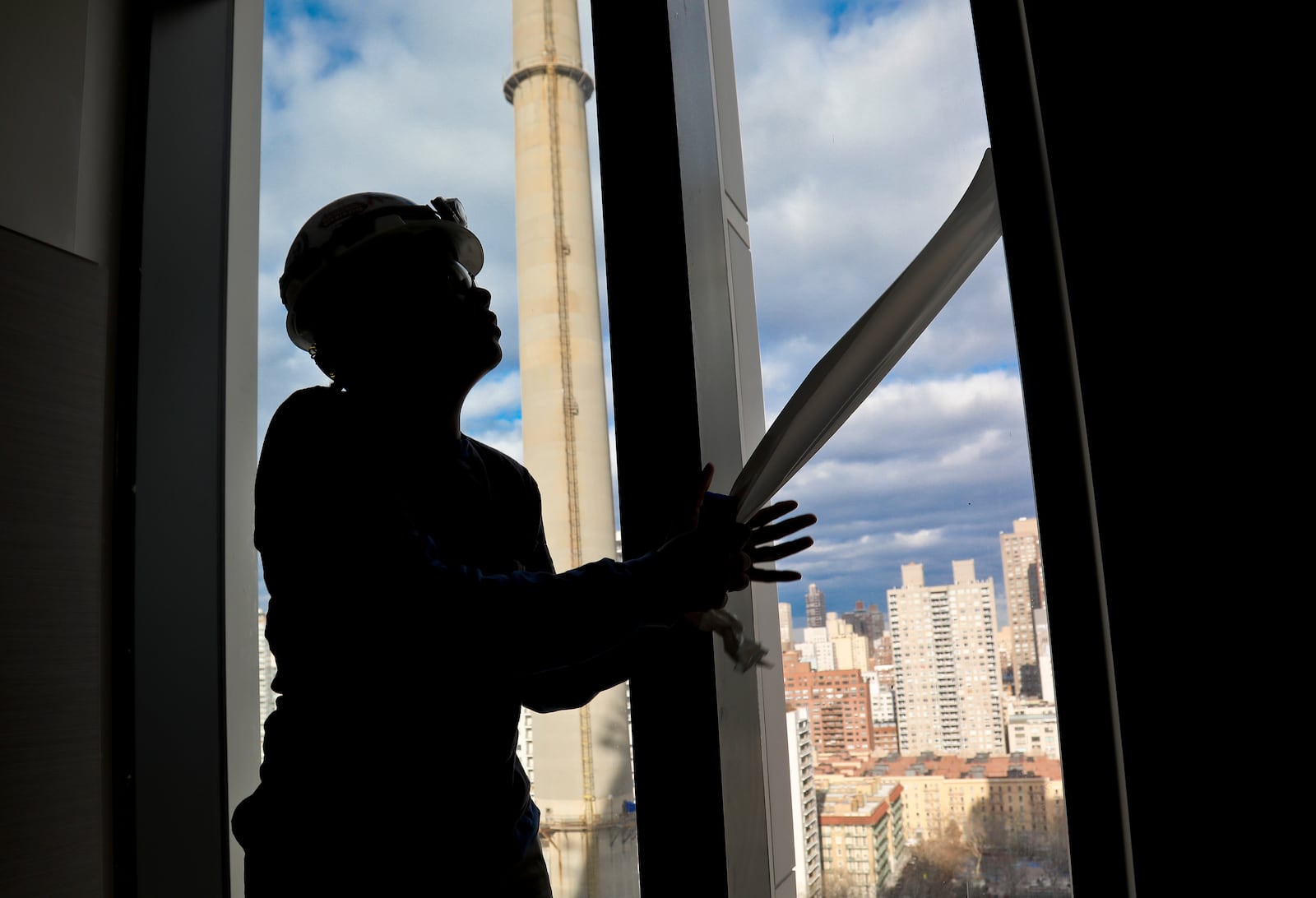 FILE - Construction laborer Myrtle Wilson prepares for a the installation of windows on a building on Jan. 9, 2019 in New York. (AP Photo/Bebeto Matthews, File)