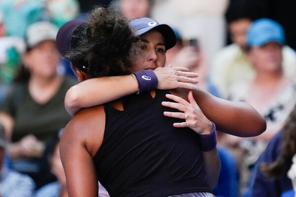 Naomi Osaka of Japan is embraced by Belinda Bencic, right, of Switzerland after she retired from their third round match at the Australian Open tennis championship in Melbourne, Australia, Friday, Jan. 17, 2025. (AP Photo/Manish Swarup)