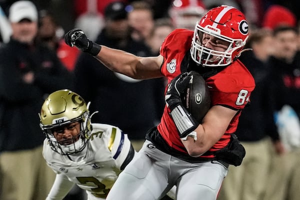 Georgia tight end Ben Yurosek (84) makes the catch agaimnst Georgia Tech defensive back Ahmari Harvey (3) during the first half of an NCAA college football game, Friday, Nov. 29, 2024, in Athens, Ga. (AP Photo/Mike Stewart)