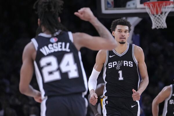 San Antonio Spurs guard Devin Vassell (24) celebrates with center Victor Wembanyama (1) during the first half of a Paris Games 2025 NBA basketball game against the Indiana Pacers in Paris, Thursday, Jan. 23, 2025. (AP Photo/Thibault Camus)