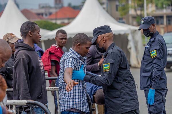 Rwanda security officials check people crossing from Congo in Gyseny, Rwanda, Tuesday, Jan. 28, 2025, following M23 rebels' advances into eastern Congo's capital Goma. (AP Photo/Yuhi Irakiza)