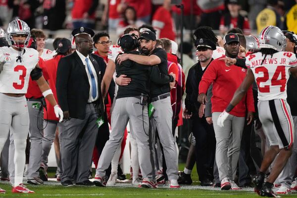 Ohio State head coach Ryan Day, center, hugs a team member after the quarterfinals of the Rose Bowl College Football Playoff against Oregon, Wednesday, Jan. 1, 2025, in Pasadena, Calif. (AP Photo/Mark J. Terrill)