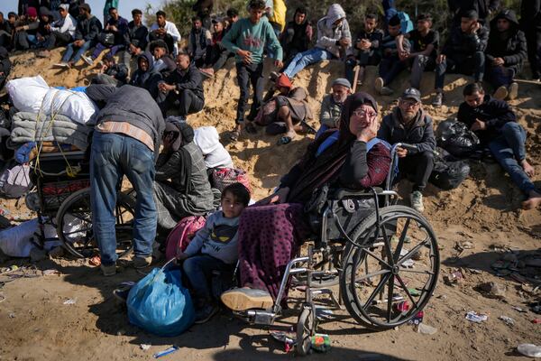 Displaced Palestinians gather with their belongings near a roadblock on the al Rashid Street, as they wait to return to their homes in the northern part of the Gaza Strip, Sunday, Jan. 26, 2025, days after the ceasefire deal between Israel and Hamas came into effect. (AP Photo/Abdel Kareem Hana)