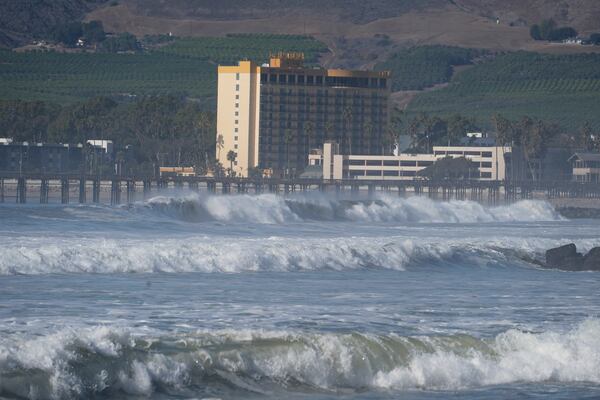 Waves crash past a pier in Ventura, Calif., Tuesday, Dec. 24, 2024. (AP Photo/Damian Dovarganes)