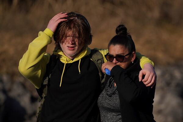 A students and a family member walk from the Antioch High School after a shooting in Nashville, Tenn., Wednesday, Jan. 22, 2025. (AP Photo/George Walker IV)