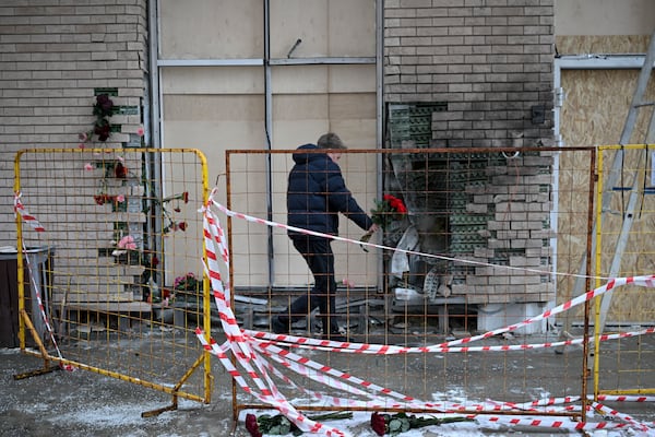 A man lays flowers at the place where Lt. General Igor Kirillov, the head of Russia's Nuclear, Biological, and Chemical Defence Forces and his assistant Ilya Polikarpov were killed by an explosive device planted close to a residential apartment's block in Moscow, Russia, Wednesday, Dec. 18, 2024. (AP Photo/Dmitry Serebryakov)