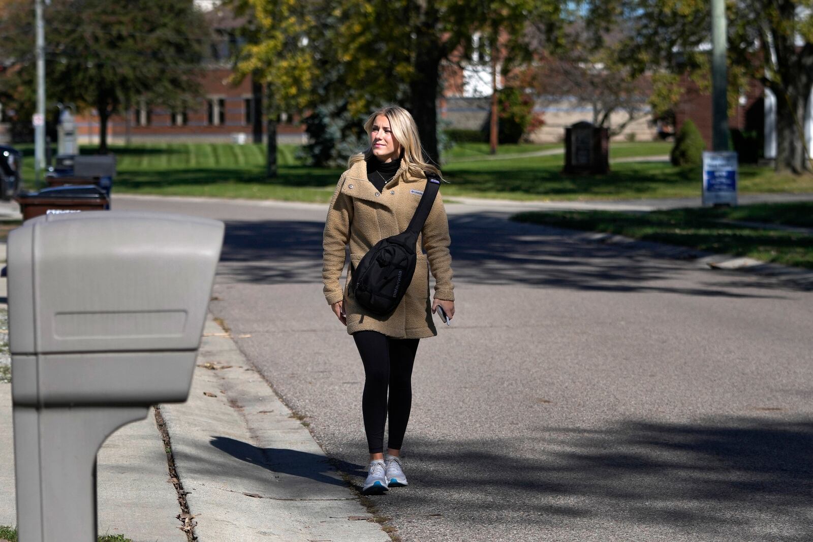 Republican Rylee Linting walks door to door campaigning hoping to unseat Democratic State Rep. Jaime Churches, Wednesday, Oct. 16, 2024, in Gibraltar, Mich. (AP Photo/Carlos Osorio)