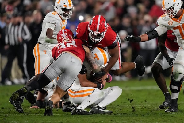 Tennessee quarterback Nico Iamaleava (8) is sacked by Georgia defensive lineman Xzavier McLeod (94) and linebacker Chaz Chambliss (32) during the first half of an NCAA college football game, Saturday, Nov. 16, 2024, in Athens, Ga. (AP Photo/John Bazemore)