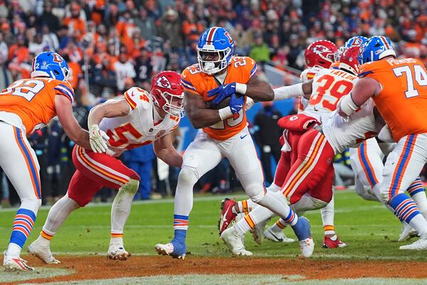 Denver Broncos running back Audric Estime (23) scores past Kansas City Chiefs linebacker Leo Chenal (54) during the second half of an NFL football game Sunday, Jan. 5, 2025, in Denver. (AP Photo/David Zalubowski)