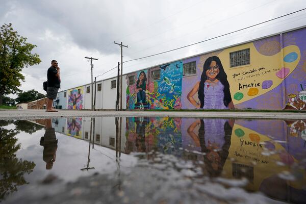 FILE - A couple visits murals created to honor the victims of the shootings at Robb Elementary School, Aug. 25, 2022, in Uvalde, Texas. (AP Photo/Eric Gay, file)