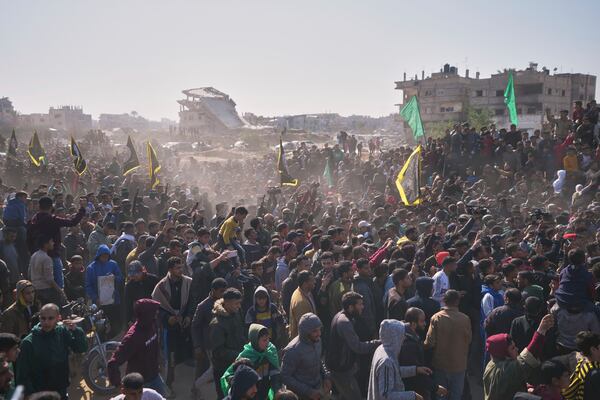 People surround the cars carrying Israeli Gadi Mozes and Arbel Yahoud, who have been held hostages by Hamas in Gaza since October 7, 2023, as they are escorted by Hamas and Islamic Jihad fighters as they are handed over to the Red Cross in Khan Younis, southern Gaza Strip, Thursday Jan. 30, 2025.(AP Photo/Abdel Kareem Hana)