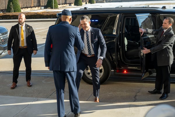 Defense Secretary Pete Hegseth, center, returns a salute to Chairman of the Joint Chiefs of Staff Gen. Charles Q. Brown Jr., as he arrives at the Pentagon, Monday, Jan. 27, 2025 in Washington. (AP Photo/Kevin Wolf)