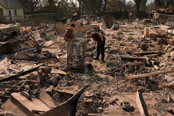 Residents dig through the rubble left behind by the Eaton Fire Friday, Jan. 10, 2025 in Altadena, Calif. (AP Photo/Jae C. Hong)